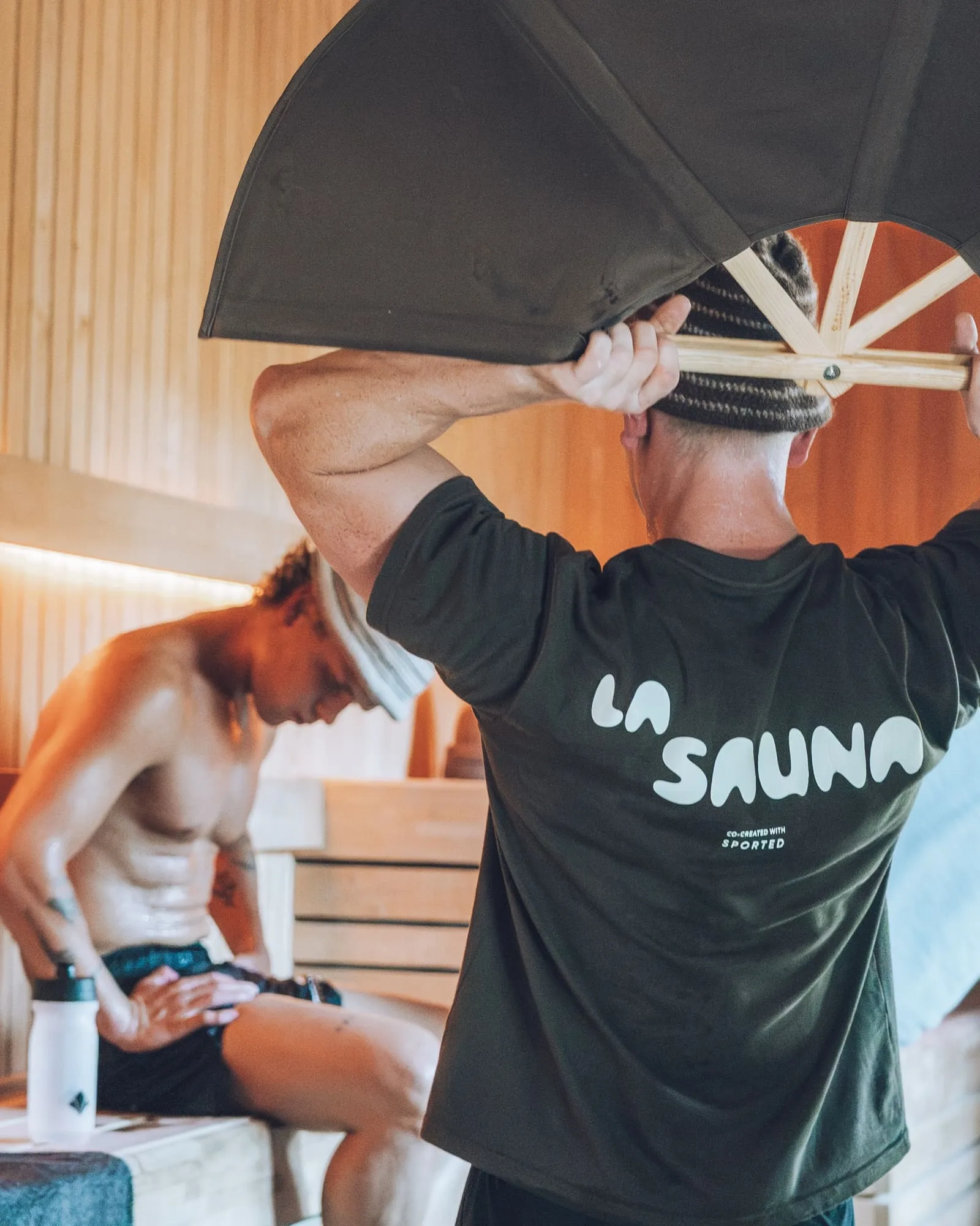 Gusmester med La Sauna-trøje fordeler varmen med en vifte