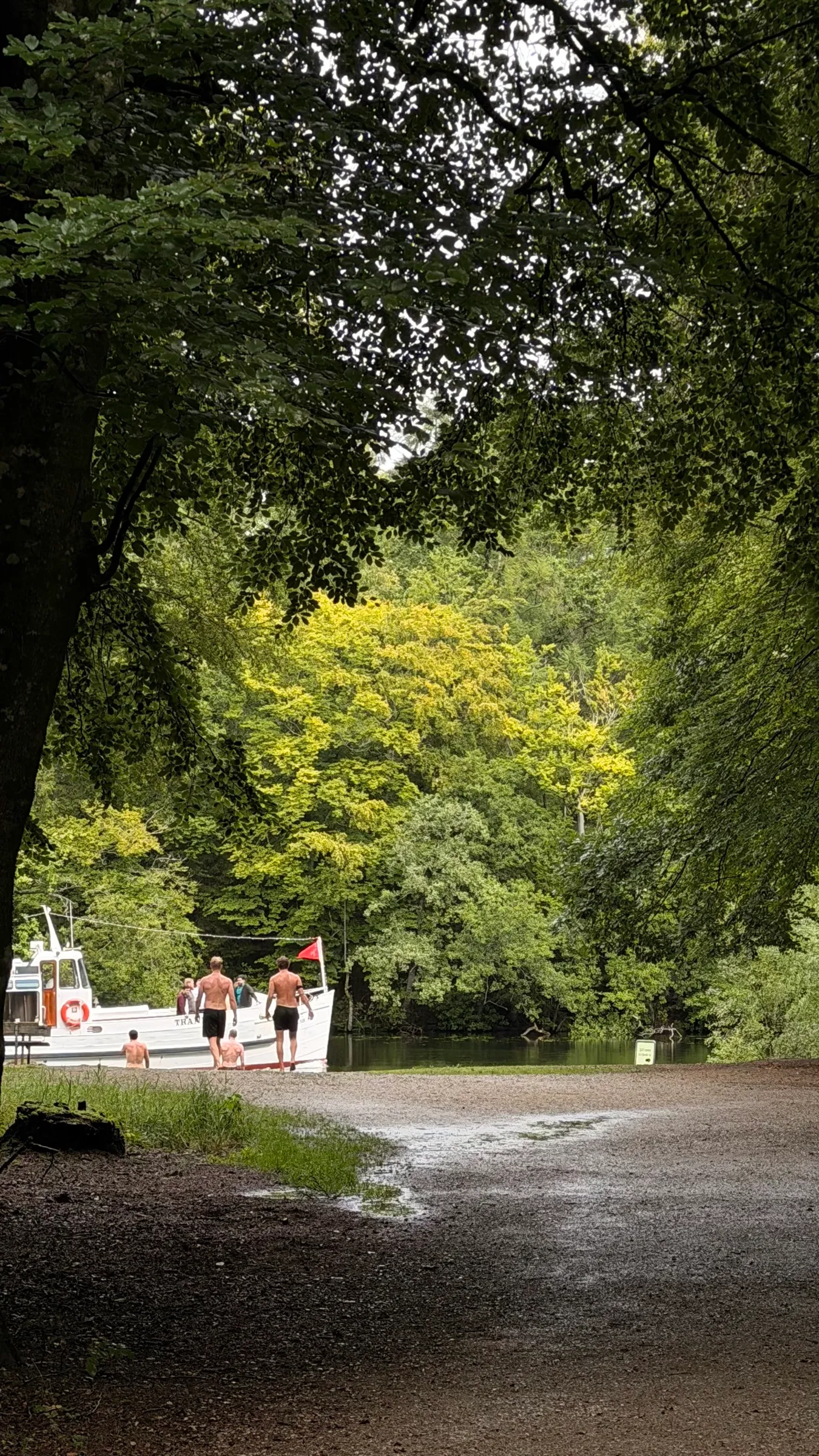 Gæster ved søen bag saunaen i Silkeborg, med en båd ved bredden