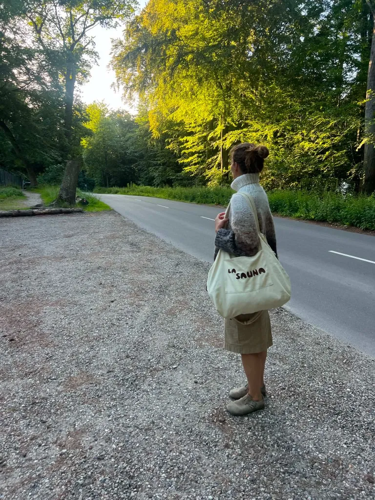 La Sauna-tote bag båret over skulderen foran skoven