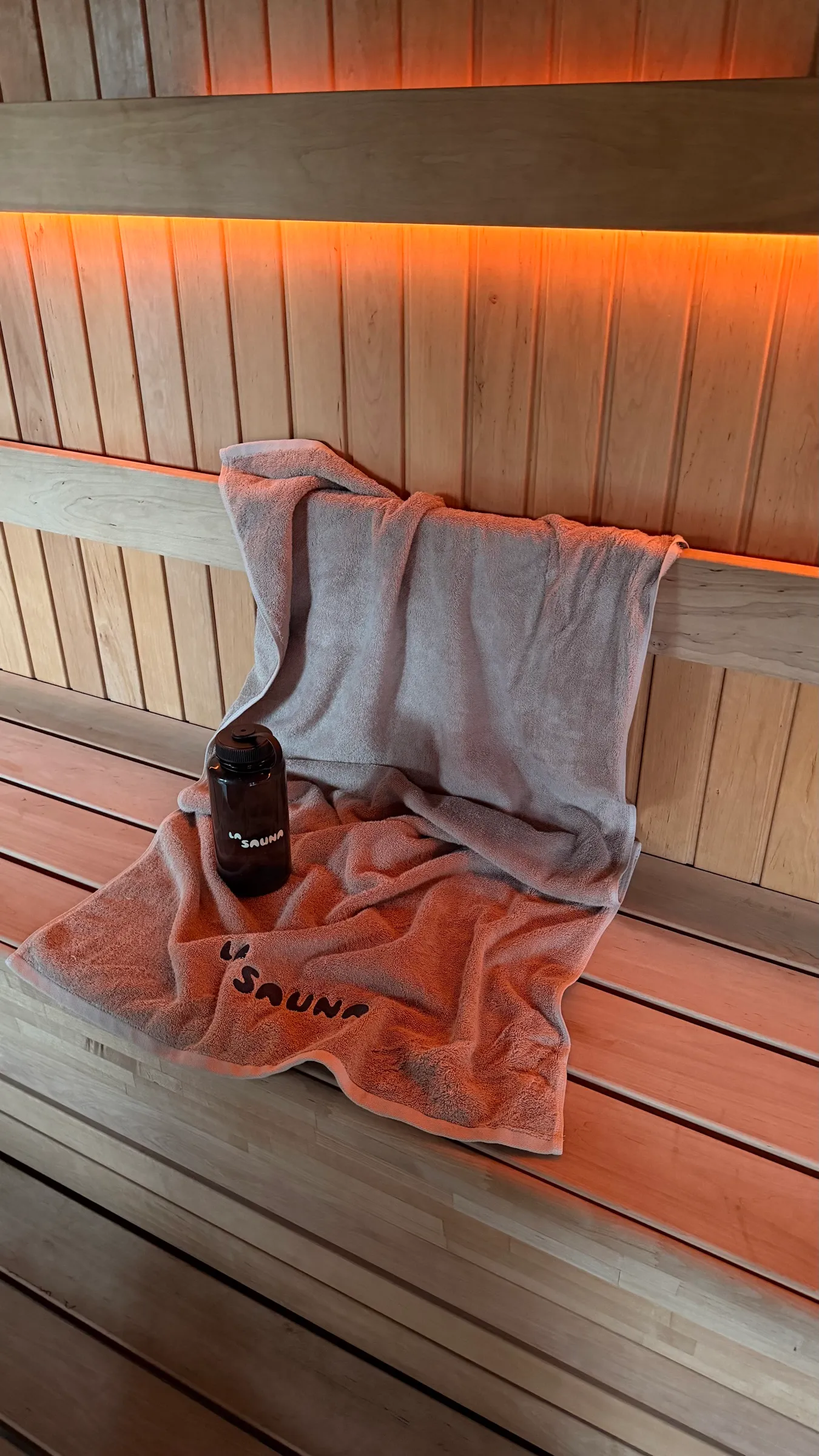 La Sauna-håndklæde og drikkedunk på saunaens bænk